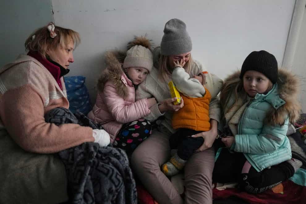 Women and children sit on the floor of a corridor in a hospital in Mariupol, eastern Ukraine (Evgeniy Maloletka/AP)