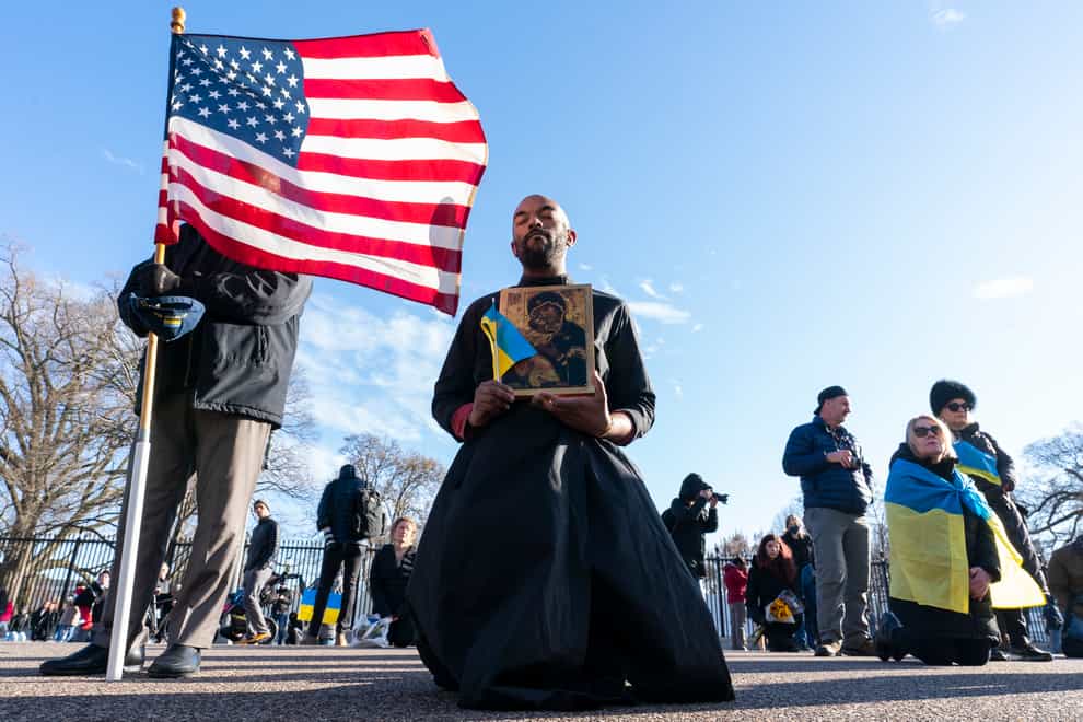 Jesuit Christopher Smith, of Washington, kneels during a moment of silence during a protest against Russia’s invasion of Ukraine in Lafayette Park near the White House (AP Photo/Alex Brandon)