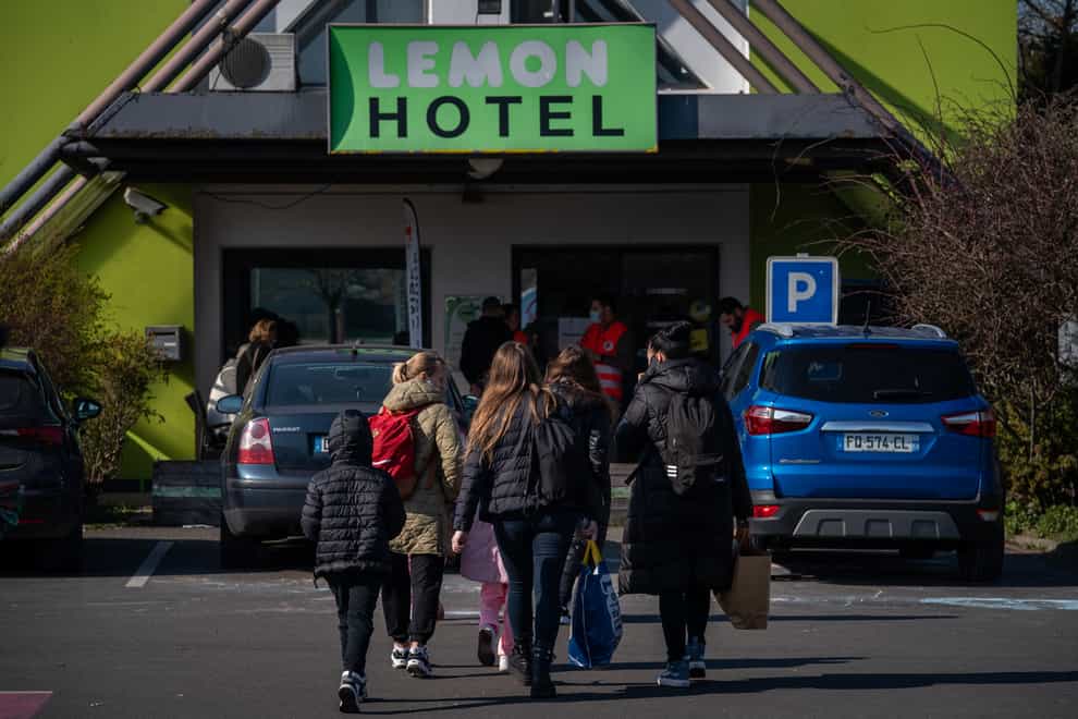 Refugees enter a budget hotel being used to house Ukrainian refugees, Lemon Hotel, in France (Aaron Chown/PA)