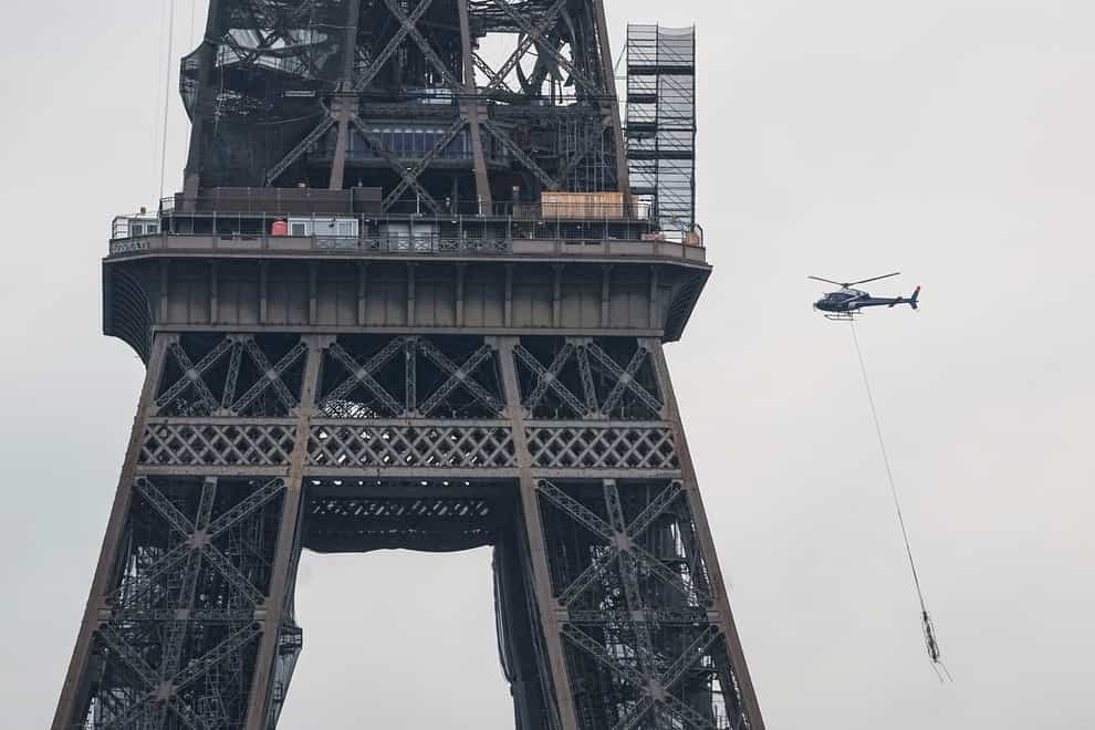 A new telecom transmission TDF (TeleDiffusion de France) antenna hanging from a helicopter as the crew flies to install it on the top of the Eiffel Tower (AP)