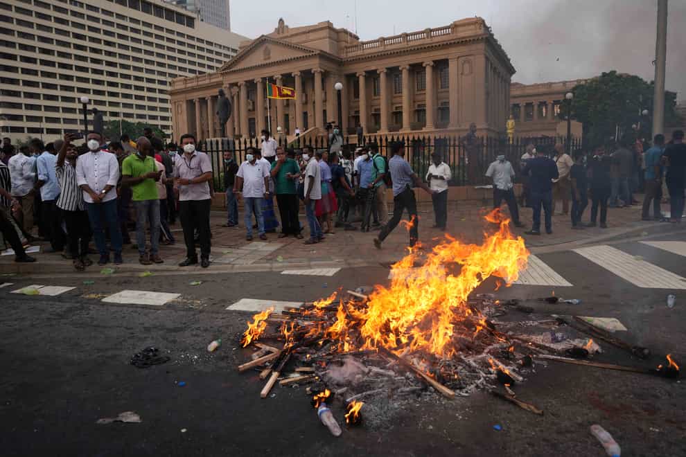 Supporters of Sri Lanka’s main opposition burn placards during a protest outside the president’s office in Colombo (AP)