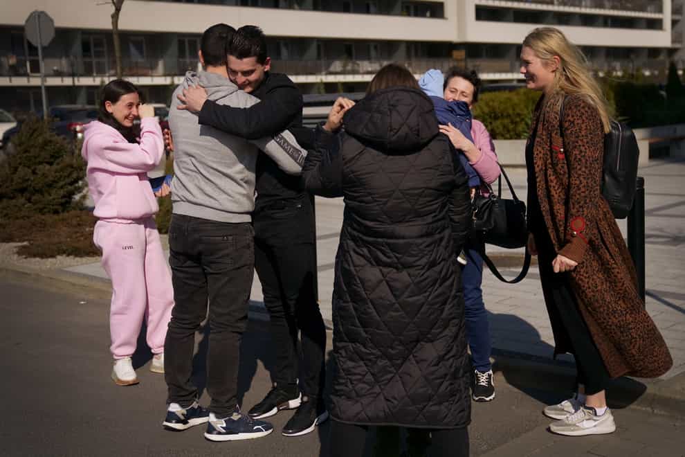 Ukrainian-born Vasyl Kucherka (third left) hugs his brother Misha Kucherka, as his sister, sister-in-law, son, mother, and partner (right) watch on in Rzeszow, Poland (Victoria Jones/PA)