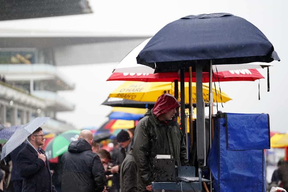 Bookmakers take shelter from the rain on day two of the Cheltenham Festival (Tim Goode/PA)