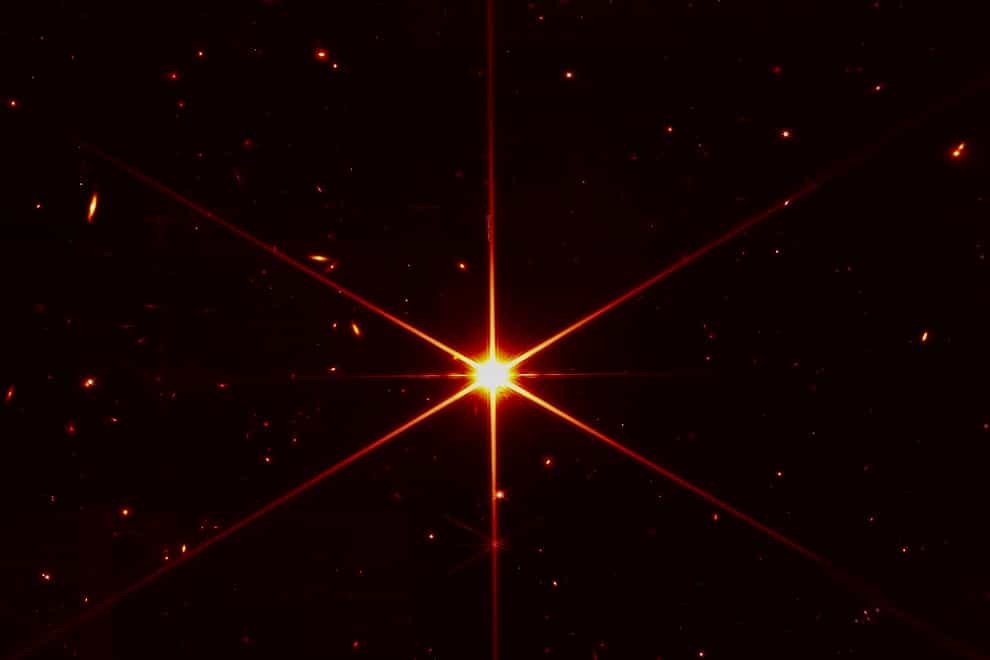 This image made available by Nasa shows star 2MASS J17554042+6551277 used to align the mirrors of the James Webb Space Telescope, with galaxies and stars surrounding it (NASA/STScI via AP)