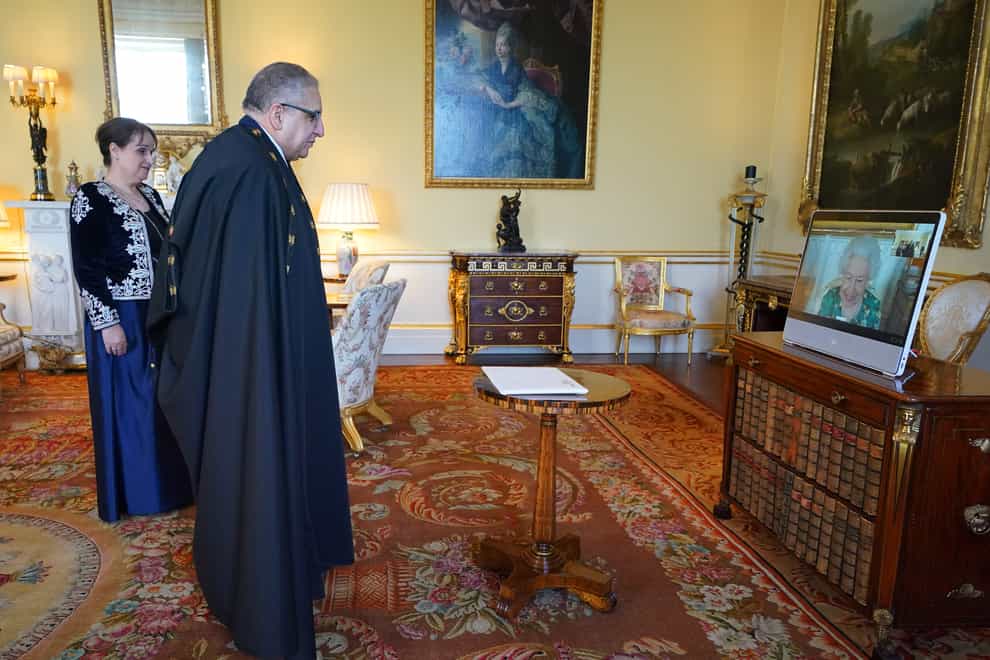 Queen Elizabeth II, in residence at Windsor Castle, appears on a screen via videolink, during a virtual audience to receive Lounes Magramane, Ambassador from the People’s Democratic Republic of Algeria, and Mrs Magramane, at Buckingham Palace (Jonathan Brady/PA)