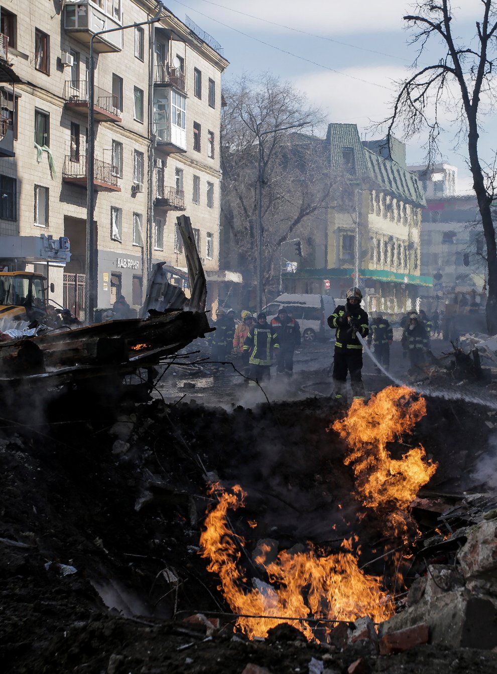 Firefighters extinguish flames outside an apartment house after a Russian rocket attack in Kharkiv (Pavel Dorogoy/AP)