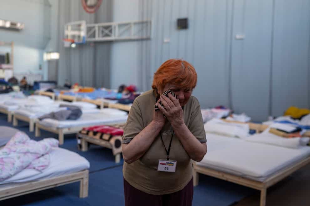 A Ukrainian refugee cries as she shelters in a school sports hall in eastern Poland (AP Photo/Petros Giannakouris)