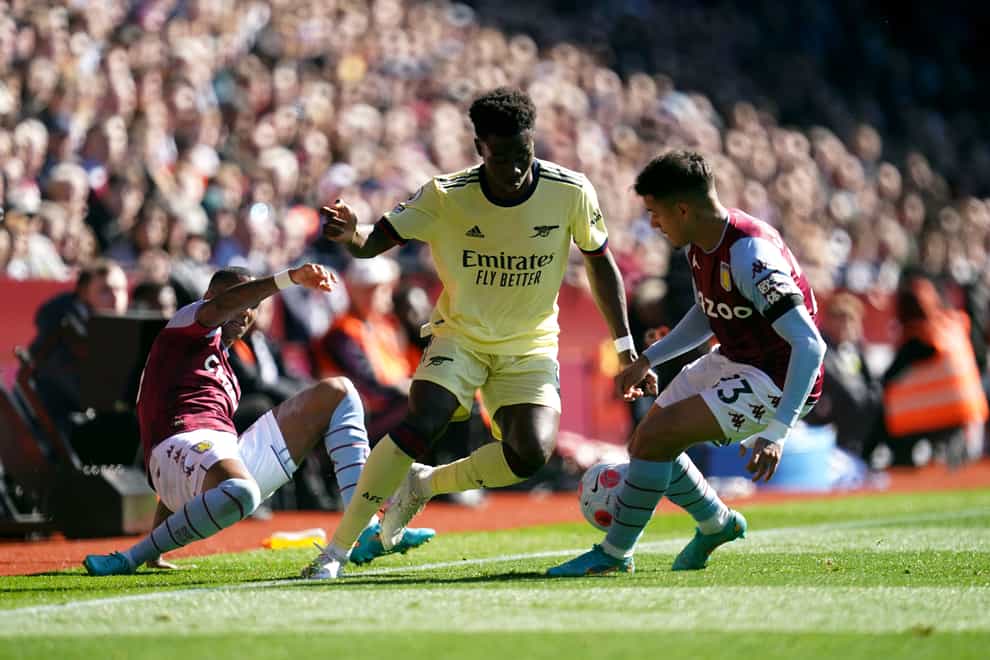 Bukayo Saka is challenged by two Aston Villa players (Nick Potts/PA)