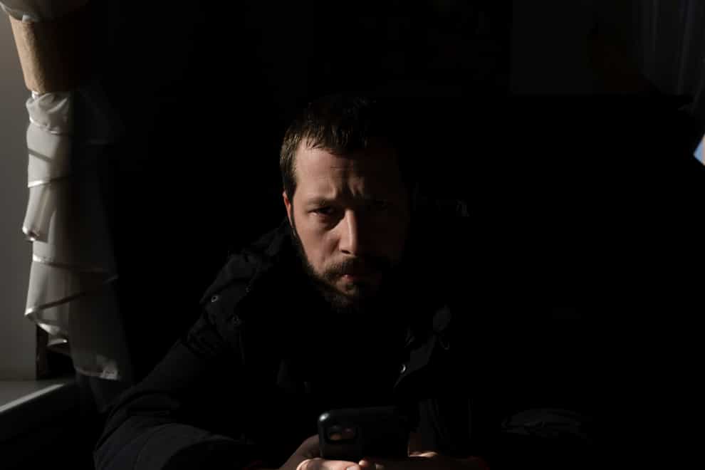 Associated Press videographer Mstyslav Chernov reads news on his phone three days before the start of the Russian invasion in Volnovakha, Ukraine (Evgeniy Maloletka/AP)