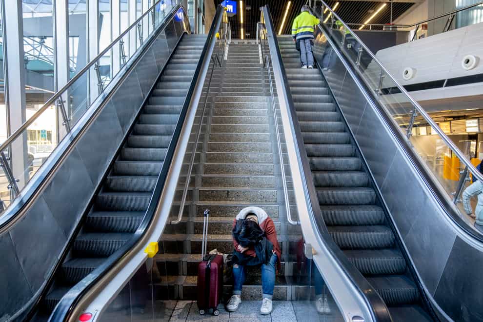 A stranded passenger rests in a terminal at the airport in Frankfurt (AP)