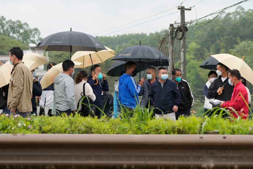 Relatives of passengers onboard the China Eastern Flight 5735 arrive near the crash site on Wednesday March 23 2022 in Lu village (Ng Han Guan/AP)