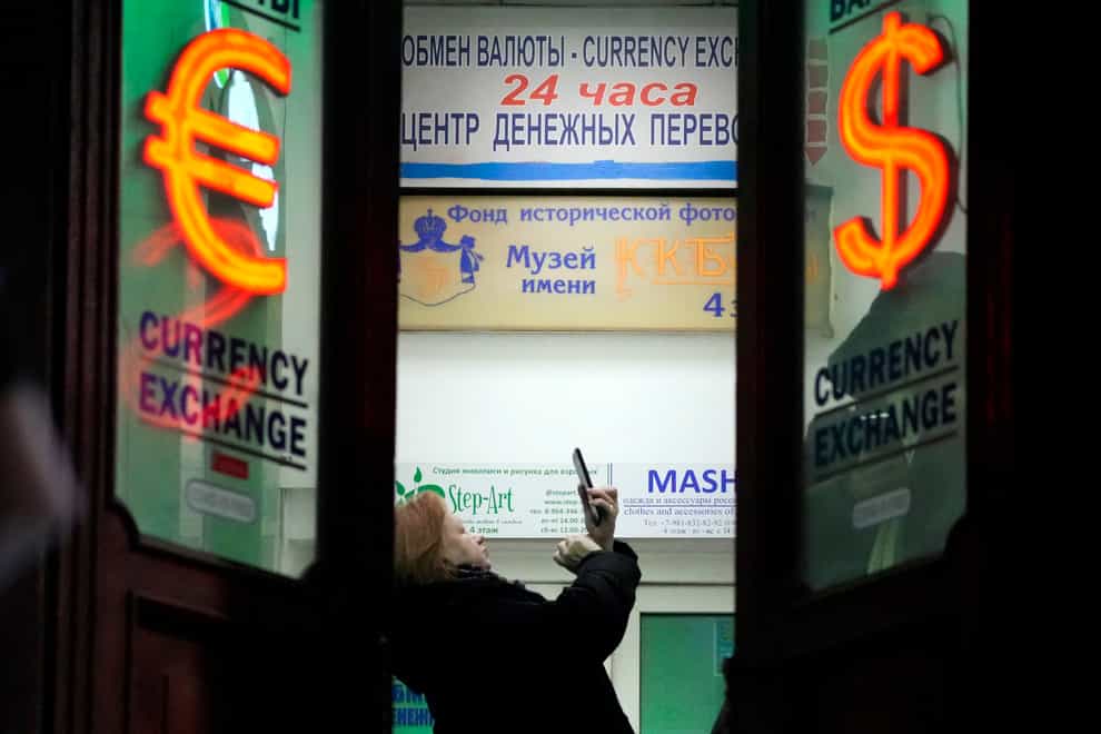 A woman stands in a currency exchange office in St Petersburg, Russia (AP)