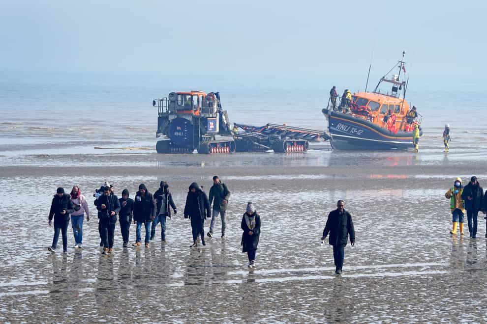 A group of people thought to be migrants are are guided up the beach after being brought in to Dungeness, Kent (Gareth Fuller/PA)