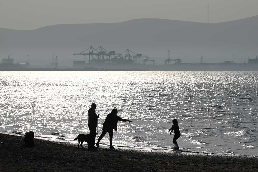 People enjoy the good weather at Seapark, Holywood, Northern Ireland, with Belfast in the distance (Michael Cooper/PA)
