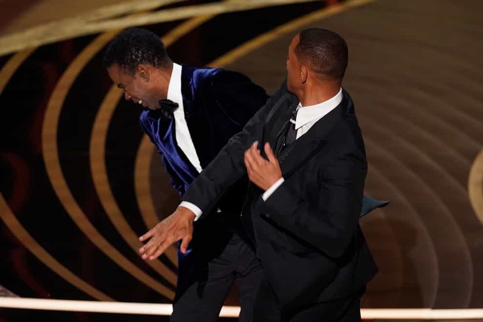 Will Smith, right, hits presenter Chris Rock on stage while presenting the award for best documentary feature (Chris Pizzello/AP)