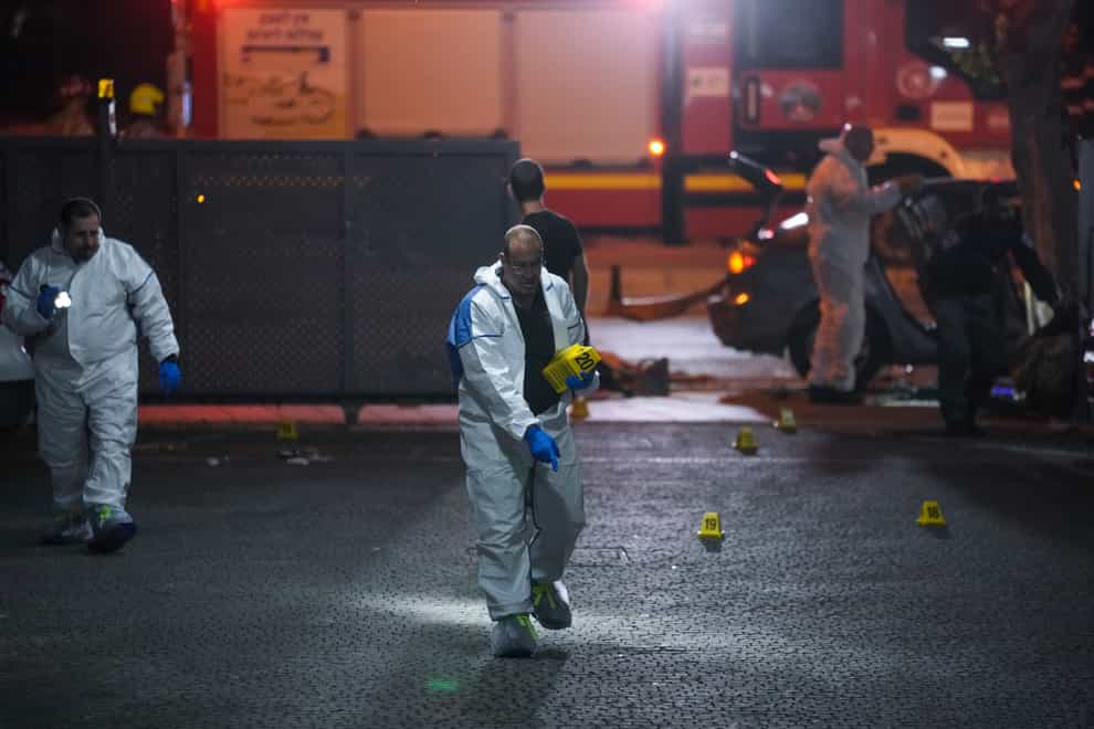 Israeli police inspect the scene of a shooting attack In Hadera (AP)