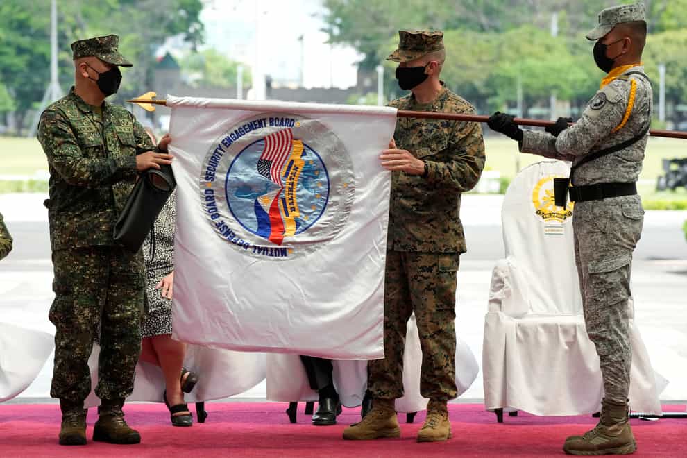 Filipino and US senior officers unfurl a flag to launch the military exercises (AP Photo/Aaron Favila)
