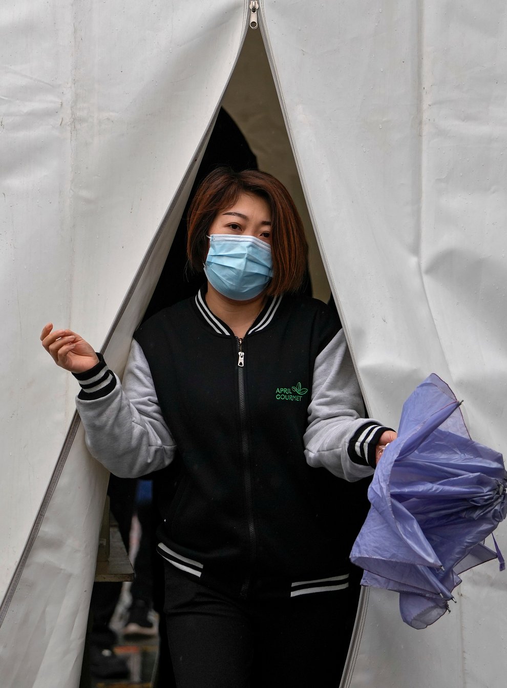 A woman wearing a face mask to help protect from the coronavirus walks out from a tent after getting a Covid-19 test (AP)