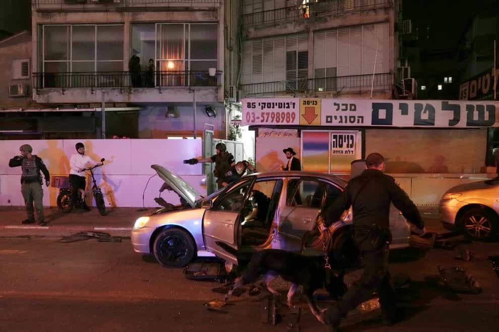 Israeli police search a car at the scene of a shooting attack in Bnei Brak (Oded Balilty/AP)