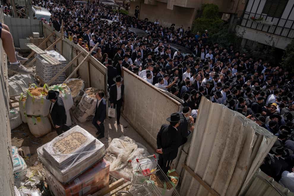 Mourners gather around the body of Avishai Yehezkel, 29, during his funeral in Bnei Brak Israel, Wednesday, March 30, 2022. Yehezkel was killed by a gunman in a crowded city in central Israel late Tuesday. (AP Photo/Oded Balilty)