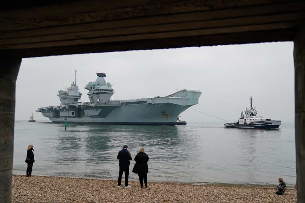 People look on as the Royal Navy aircraft carrier HMS Queen Elizabeth arrives back in Portsmouth (Andrew Matthews/PA)