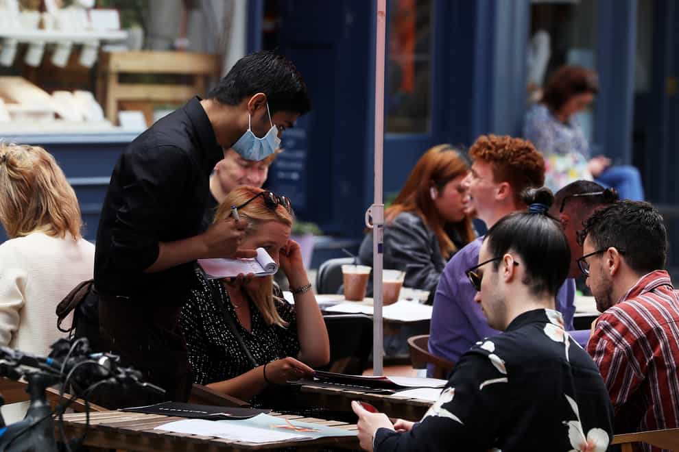 A waiter takes orders at a restaurant. VAT on food is set to increase among a raft of tax changes coming into force in April (Brian Lawless/PA)