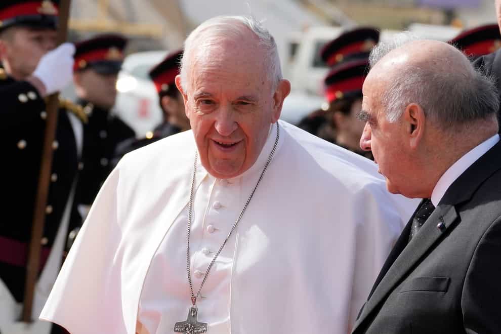 Pope Francis, left, is received by Malta’s President George Vella, upon his arrival at Malta International airport in Luqa, Saturday, April 2, 2022. Pope Francis headed to the Mediterranean island nation of Malta on Saturday for a pandemic-delayed weekend visit, aiming to draw attention to Europe’s migration challenge that has only become more stark with Russia’s invasion of Ukraine. (AP Photo/Andrew Medichini)