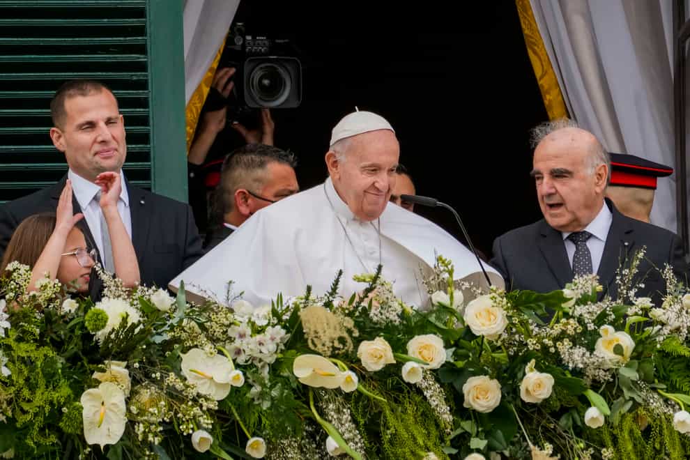 Pope Francis, center, with, from left, Malta Prime Minister Robert Abela, with daughter Giorgia Mae, and Malta’s President George William Vella, right, looks at a cheering crowd from a balcony of the Grand Master’s Palace in Valletta, Malta, Saturday, April 2, 2022. Pope Francis headed to the Mediterranean island nation of Malta on Saturday for a pandemic-delayed weekend visit, aiming to draw attention to Europe’s migration challenge that has only become more stark with Russia’s invasion of Ukraine. (AP Photo/Andrew Medichini)
