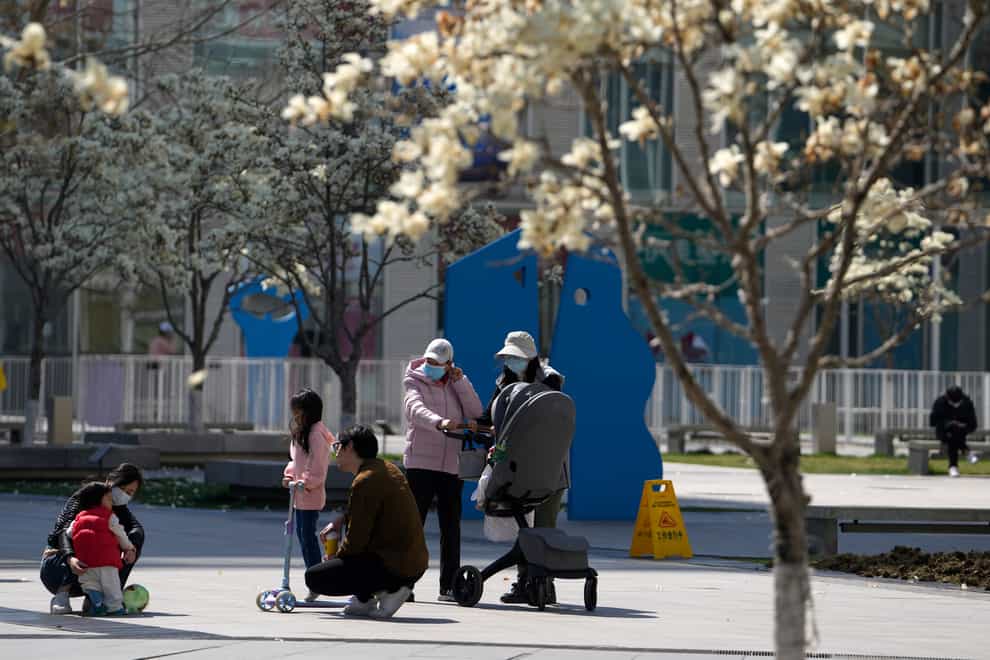 Residents enjoy the sunshine in Beijing (Andy Wong/AP)
