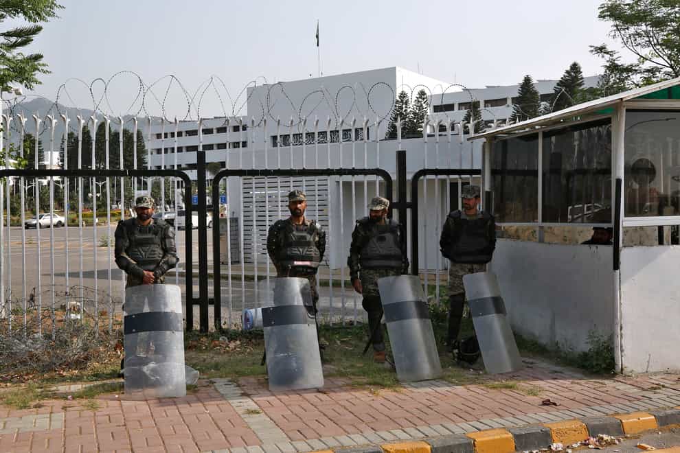Pakistani paramilitary troops in riot gear stand guard outside the National Assembly, in Islamabad (Anjum Naveed/AP)
