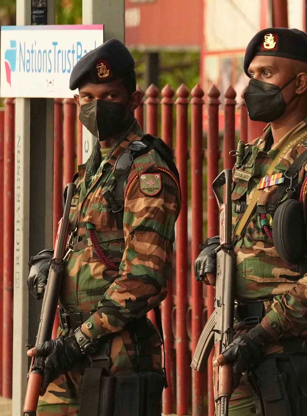 Sri Lankan soldiers stand guard before the curfew begins in Colombo (Eranga Jayawardena/AP)
