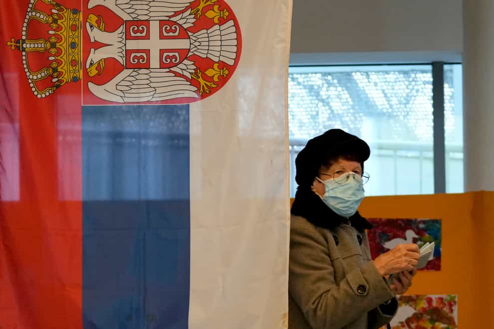 A woman prepares to vote at a polling station in Belgrade (Darko Vojinovic/AP)