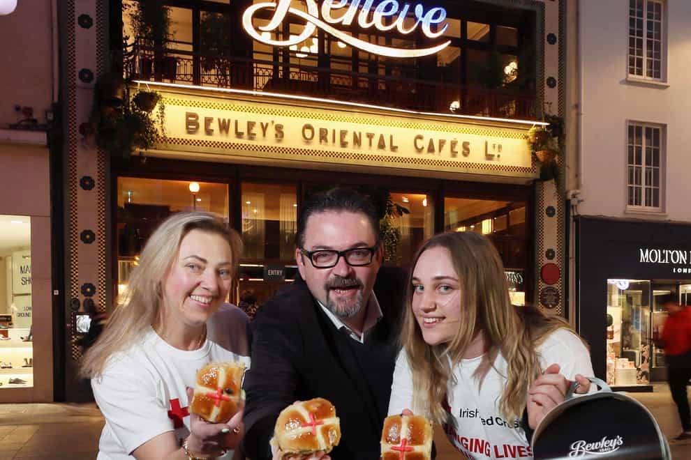 Ukrainian nationals and interpreters, Oksana Karbiwska (left) and her daughter Kamilia Karbiwska (right), pictured with Frank Phelan, Irish Red Cross, at Bewley’s Grafton Street Cafe in Dublin, which has designed a special range of ‘Red Cross Buns’, all sales proceeds of which go to the Ukraine humanitarian effort (Robbie Reynolds/PA)