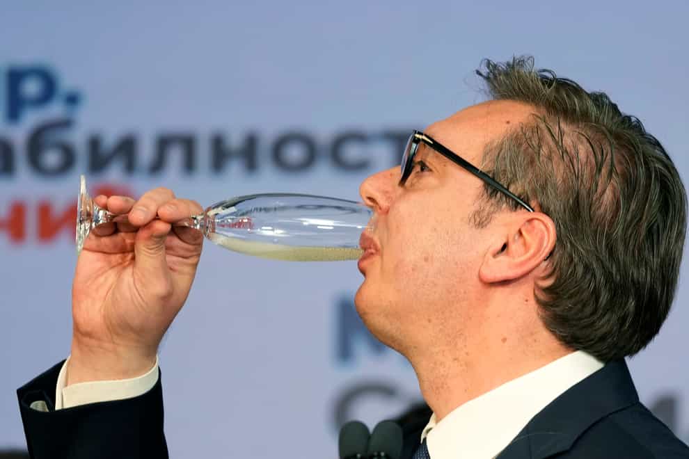 Aleksandar Vucic drinks champagne after claiming victory in the election (Darko Vojinovic/AP)