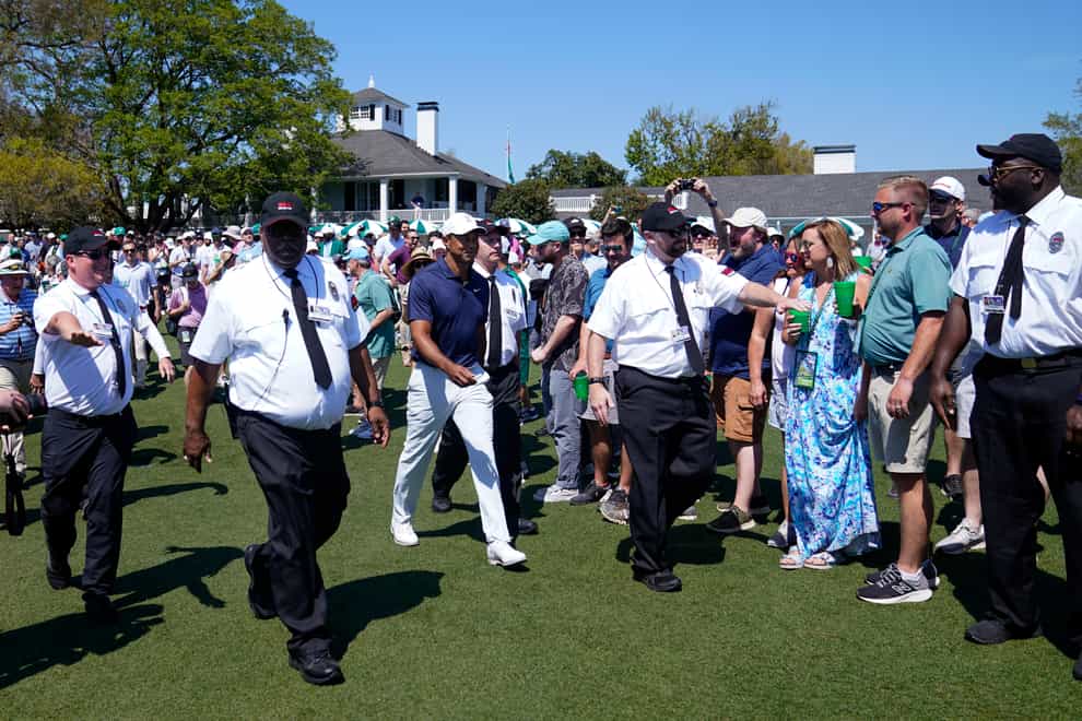 Security clears a path for Tiger Woods as he walks to the practice green at Augusta National on Monday (Jae C. Hong/AP)