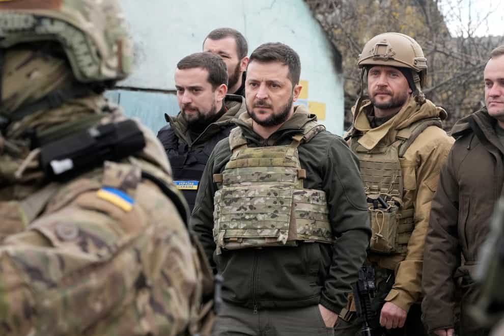 Ukrainian President Volodymyr Zelenskyy examines the site of a recent battle in Bucha, close to Kyiv, Ukraine, Monday, Apr. 4, 2022. Russia is facing a fresh wave of condemnation after evidence emerged of what appeared to be deliberate killings of civilians in Ukraine. (AP Photo/Efrem Lukatsky)