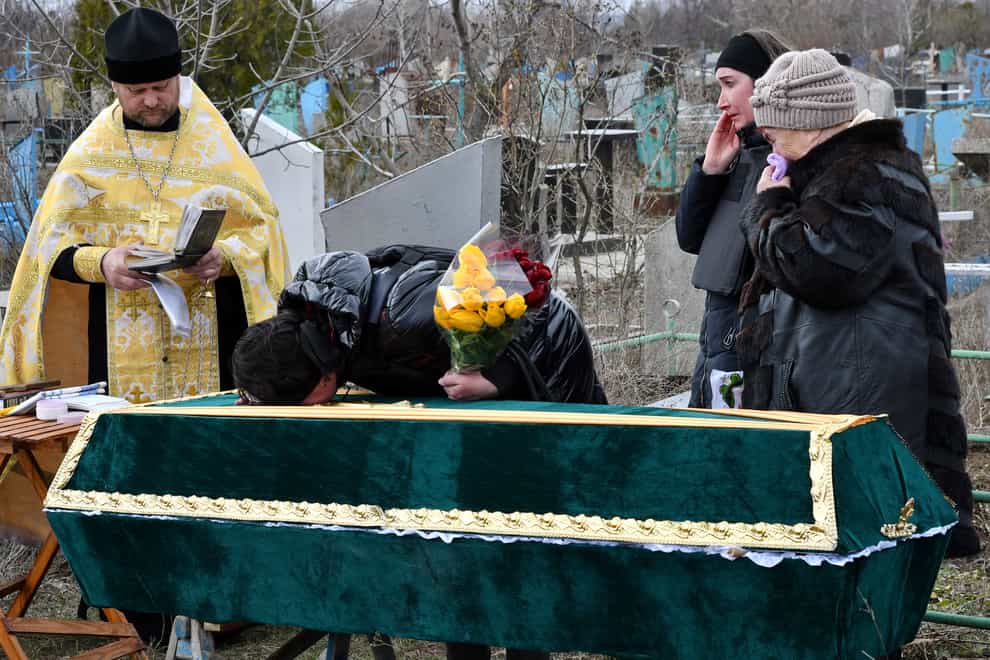Relatives and friends stand near the coffin of Ukrainian serviceman Anatoly German during a funeral ceremony in Kramatorsk, Ukraine (Andriy Andriyenko/AP)