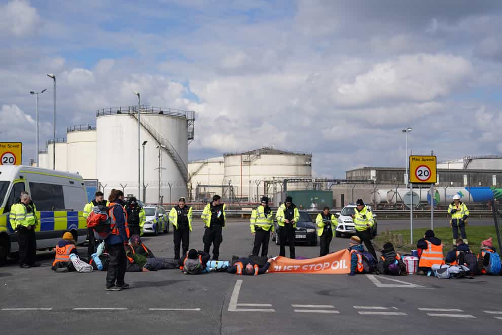 Police officers look at activists from Just Stop Oil taking part in a blockade at the Kingsbury Oil Terminal, Warwickshire, on Sunday (Jacob King/PA)