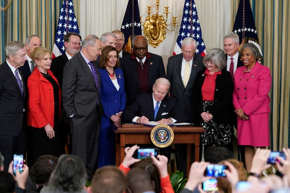 President Joe Biden signs the Postal Service Reform Act of 2022 in the State Dining Room at the White House in Washington, April 6, 2022. Nancy Pelosi has tested positive for Covid-19, her spokesman says (Susan Walsh/AP)