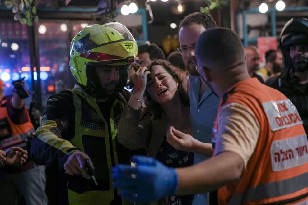 A woman reacts at the scene of a shooting attack In Tel Aviv, Israel, on Thursday April 7 2022 (Ariel Schalit/AP)