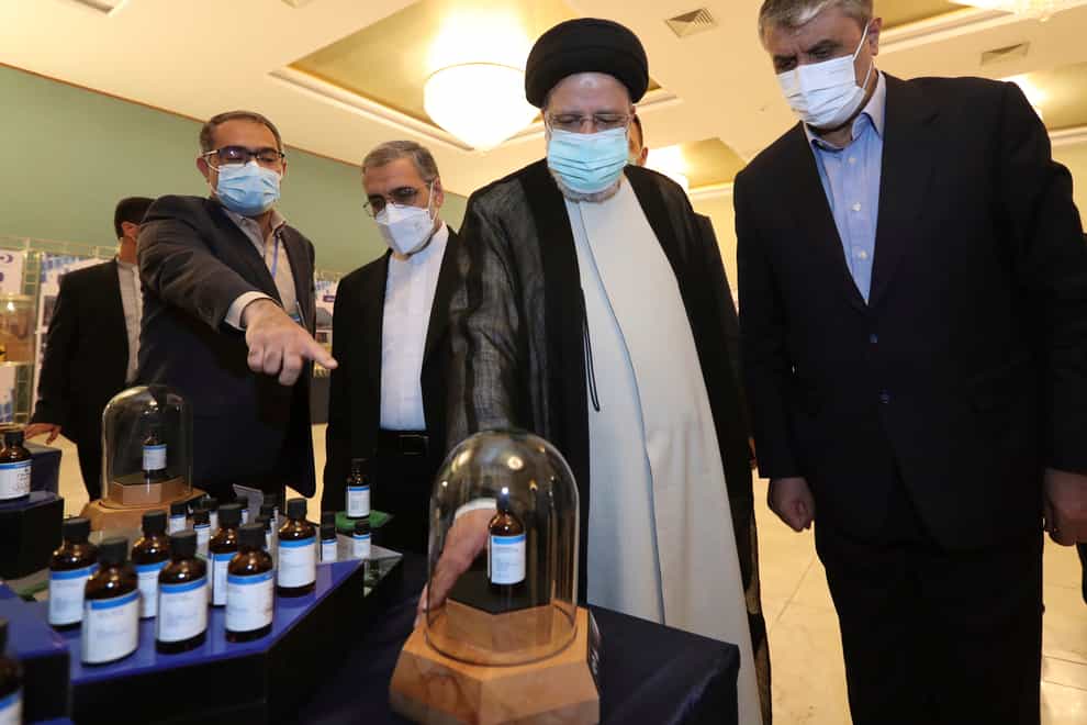 President Ebrahim Raisi, second right, receives an explanation while visiting an exhibition of Iran’s nuclear achievements in Tehran (Iranian Presidency Office via AP)