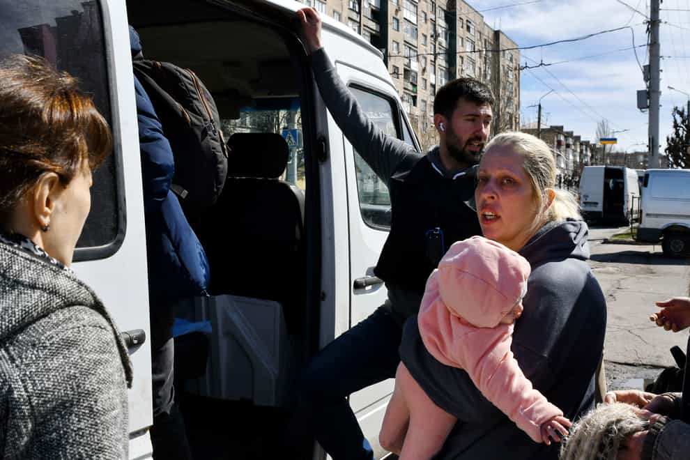 A woman with a child boards a bus as civillians are evacuated in Kramatorsk, Ukraine (Andriy Andriyenko/AP)