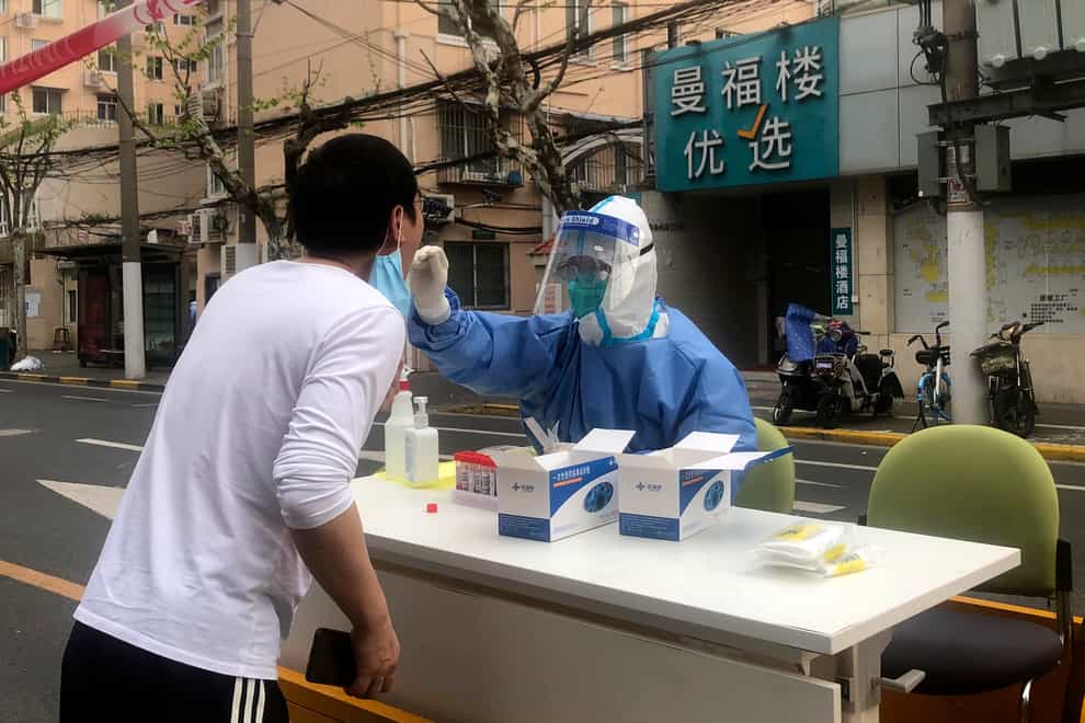 A medical worker conducts Covid-19 tests for residents after a confirmed case was found in the community in Shanghai (AP Photo/Chen Si)