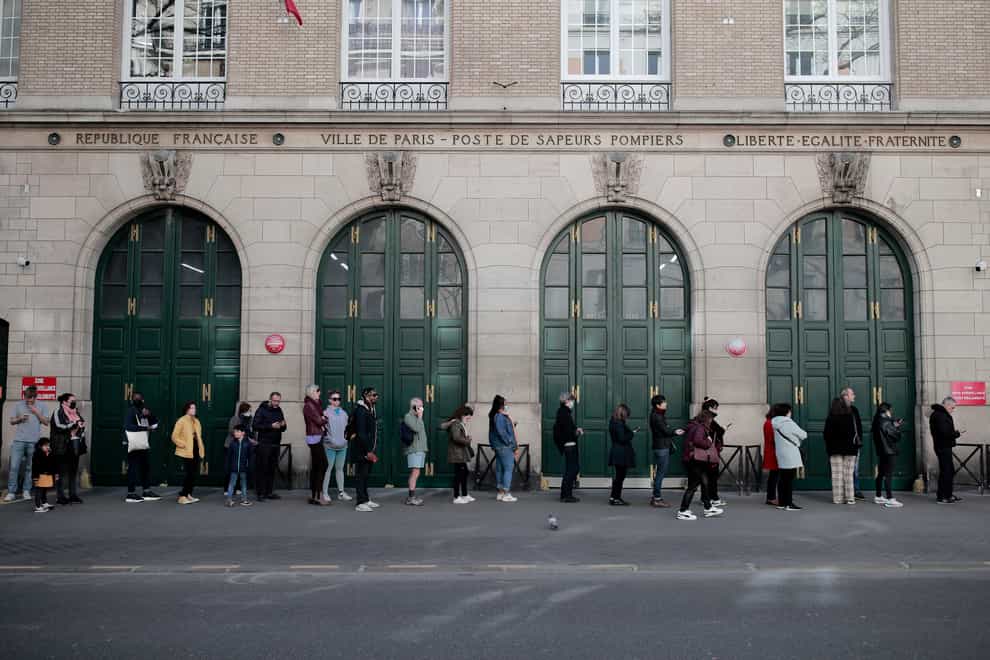 People queue before voting in the first round of the French presidential election in Paris (AP Photo/Lewis Joly)