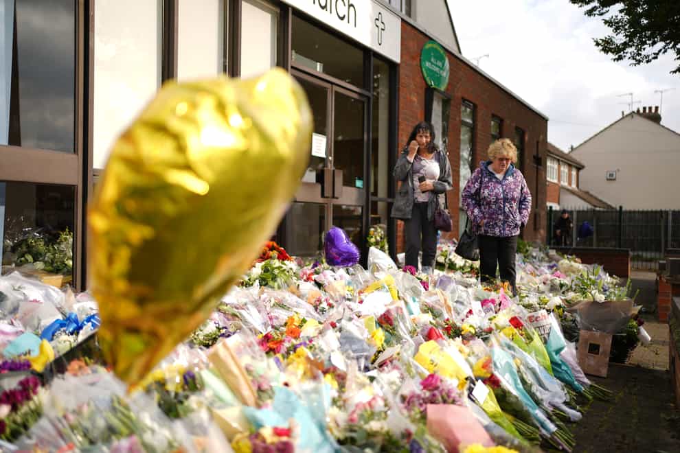 People look at the floral tributes left outside the Belfairs Methodist Church in Leigh-on-Sea (PA)