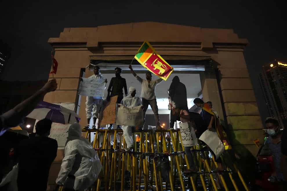 Sri Lankans shout anti government slogans blocking the entrance to president’s office during a protest in Colombo (AP)