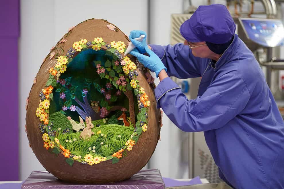 Chocolatier Dawn Jenks adds the finishing touches to the Easter-themed chocolate creation at Cadbury World (Jacob King/PA)