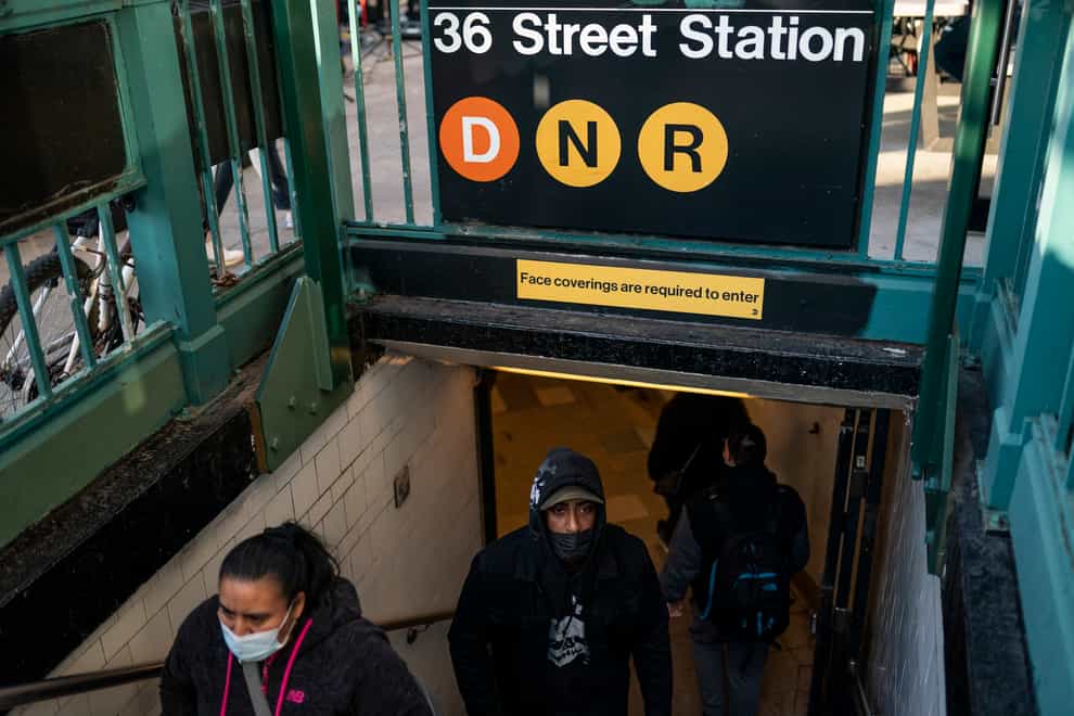 Pedestrians exit the 36th Street subway station where a shooting occurred the previous day (John Minchillo/AP)