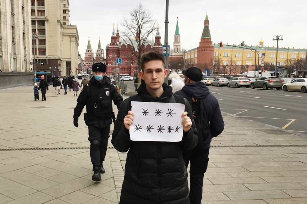 Police prepare to detain Dmitry Reznikov holding a piece of paper with eight asterisks (SOTA/AP)