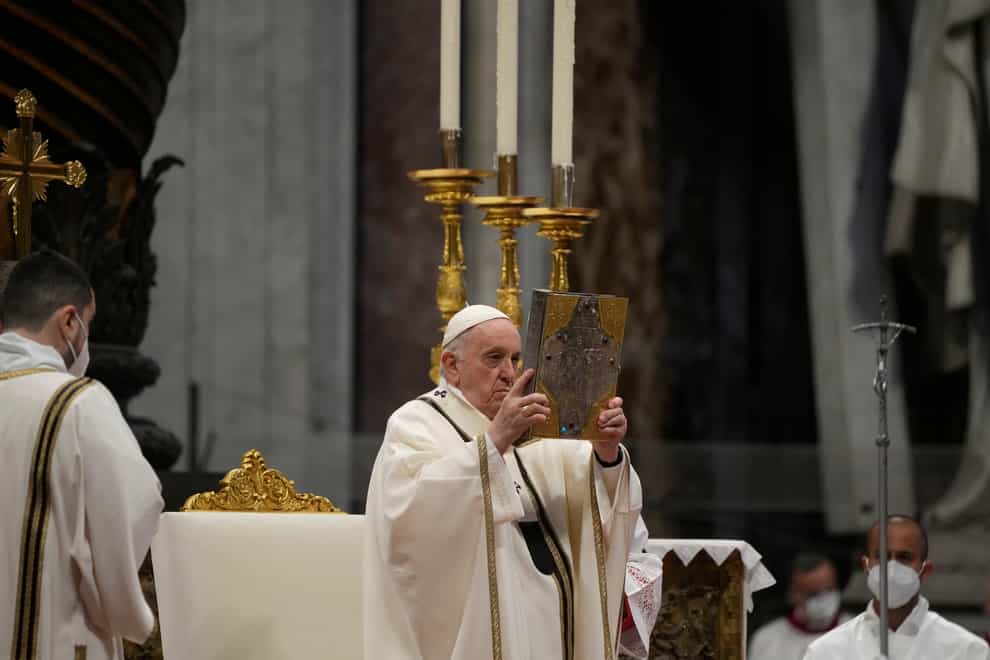 Pope Francis hoists the Godspell book during a Chrism Mass inside St Peter’s Basilica at the Vatican (Gregorio Borgia/AP)